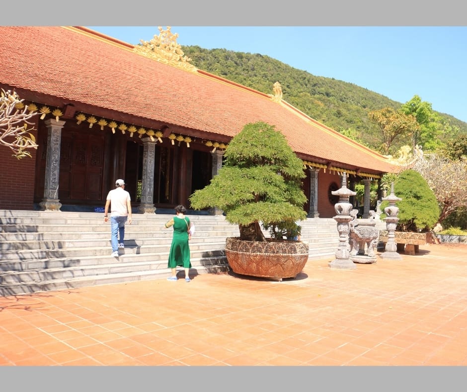 Thềm đá rộng trước chánh điện mái ngói đỏ, cạnh chậu cây cảnh lớn