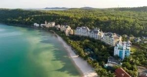 Bãi cát trắng hình cánh cung nhìn từ trên cao, resort dọc bờ